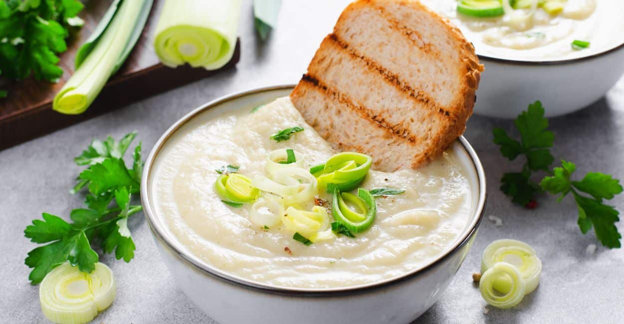 Tigela de vichyssoise francesa gelada, decorada com cebolinha picada.