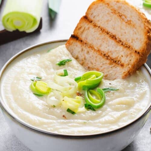 Tigela de vichyssoise francesa gelada, decorada com cebolinha picada.