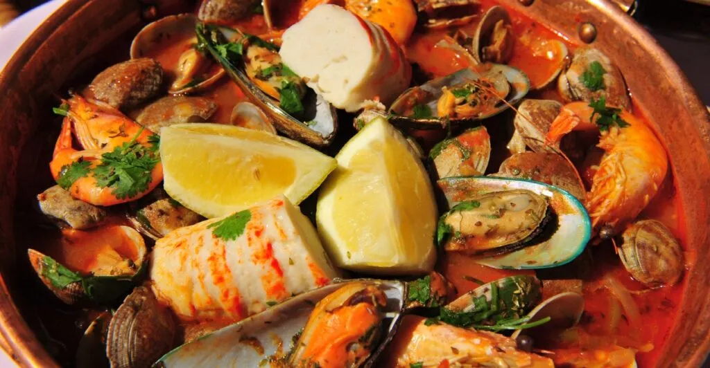 Cataplana de frutos do mar com camarões, mexilhões e amêijoas, preparada na tradicional panela de cobre, prato típico da culinária portuguesa.