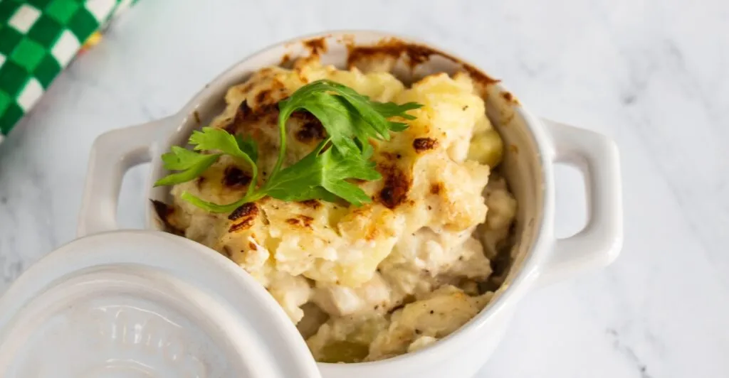 Bacalhau com natas gratinado no forno, servido em travessa rústica, prato típico da culinária portuguesa.