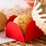 brigadeiro gourmet junino de paçoca exposto em forminha vermelha de papel e decorado com mini chapéu de palha.