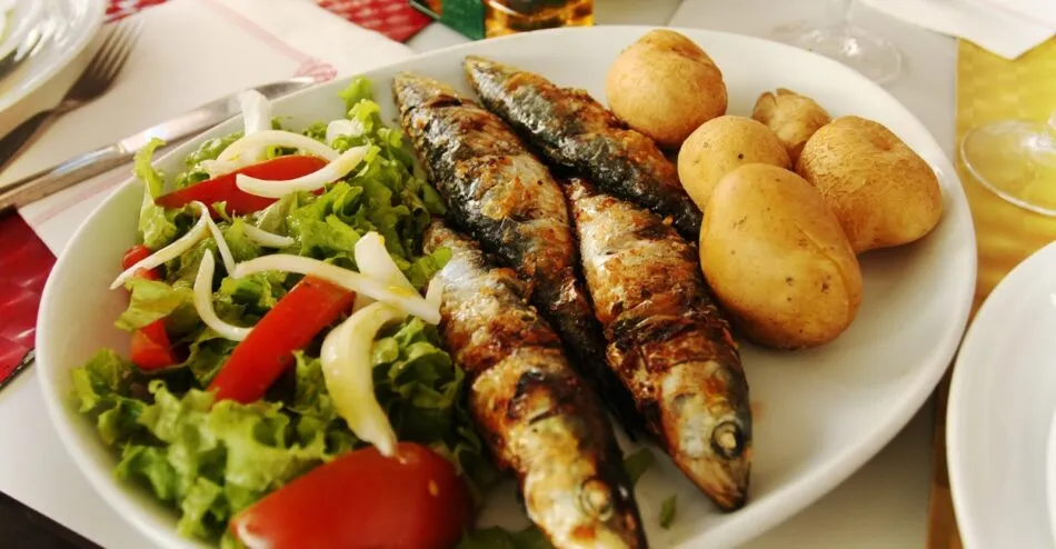 Sardinhas assadas na brasa, servidas com pimentão e pão, prato tradicional da culinária portuguesa.