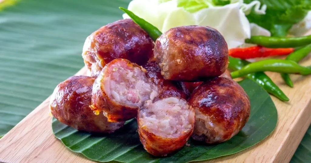 Linguiça artesanal assada na brasa com aparência suculenta, comida de festa junina salgada.