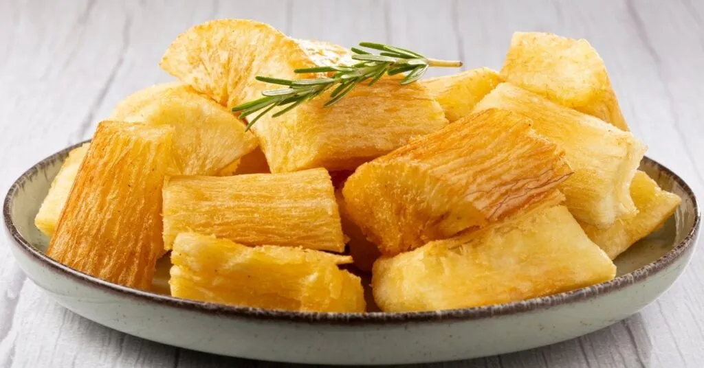 Tiras de mandioca frita douradas e crocantes, comida de festa junina salgada.