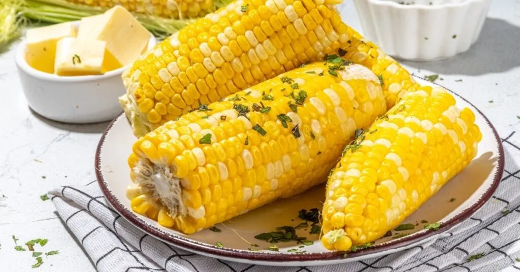Espigas de milho cozido servidas quentes, comida de festa junina salgada.