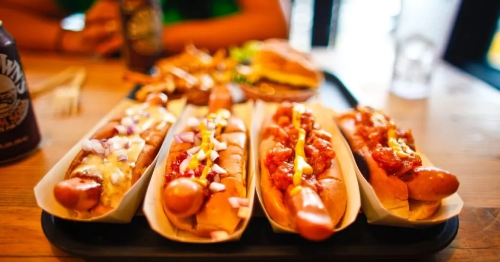 Cachorro-quente com molho caseiro e batata palha servido em festa junina, comida de festa junina salgada.