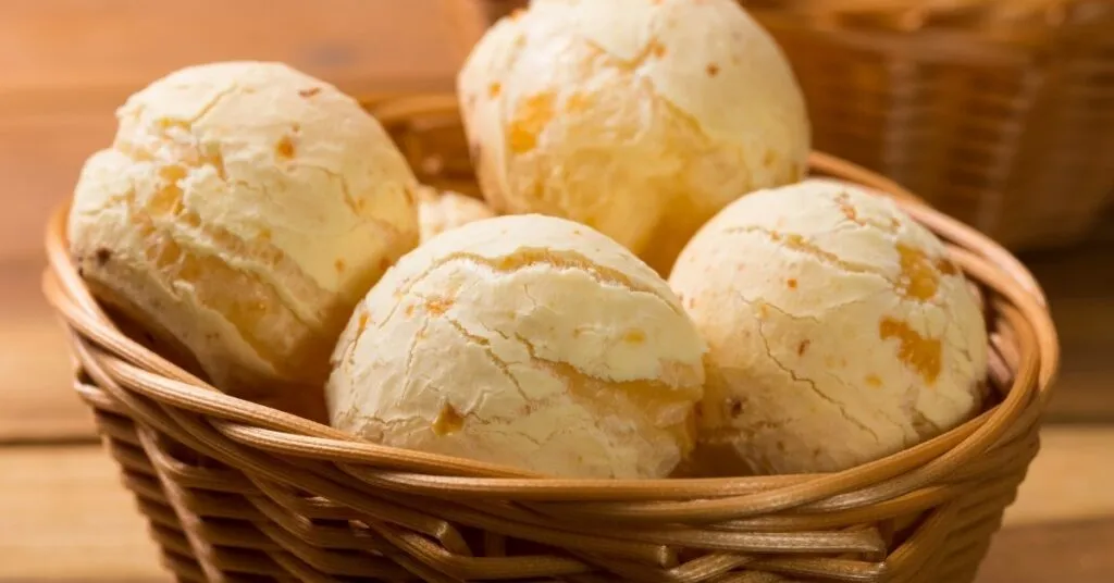 Pães de queijo dourados e macios em mesa típica de festa junina, comida de festa junina salgada.