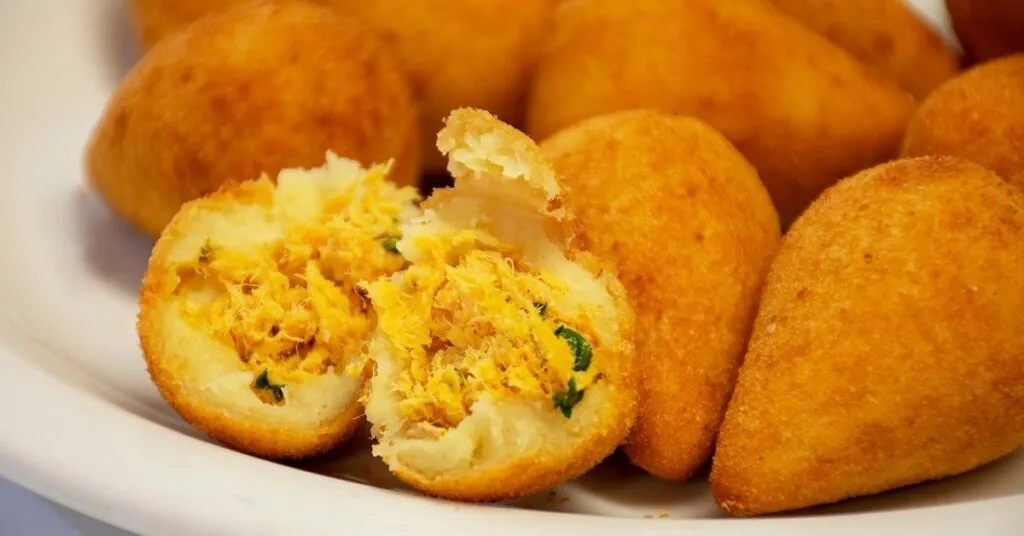 Coxinhas douradas e crocantes servidas em mesa junina, comida de festa junina salgada.